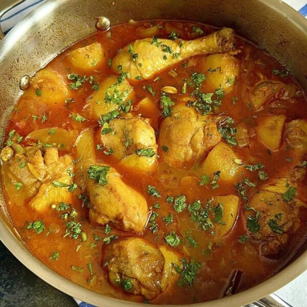 Chicken curry in sauce pan with potatoes and chillis