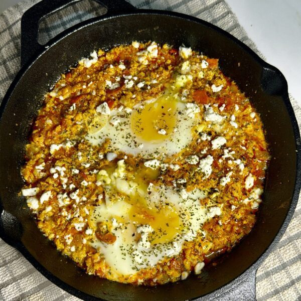 Chicken shakshuka in cast iron skillet and runny eggs