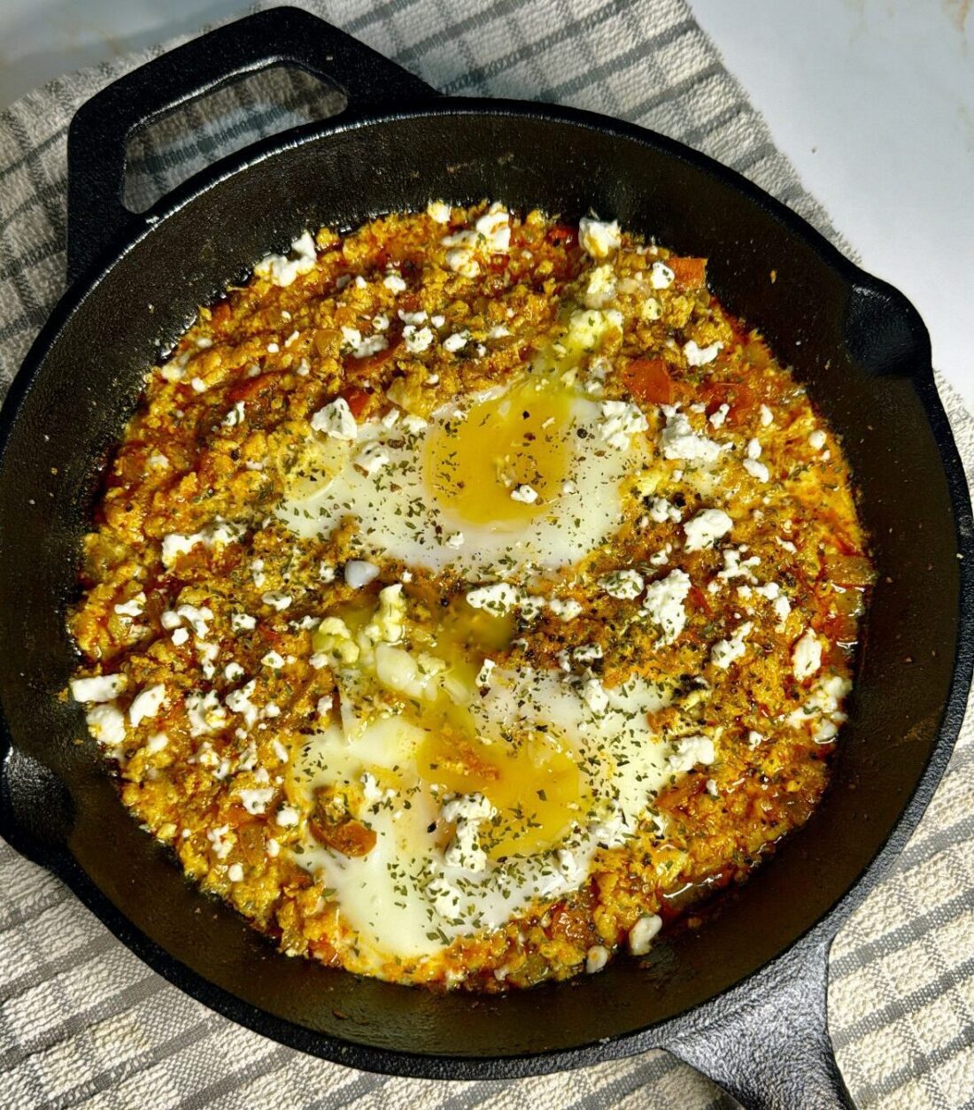 Chicken shakshuka in cast iron skillet and runny eggs