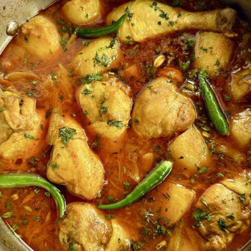 chicken drumsticks in curry sauce with potatoes and chilli