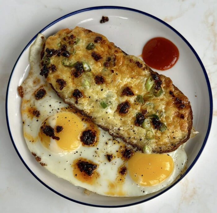 Toast with melted cheese and two eggs on the side