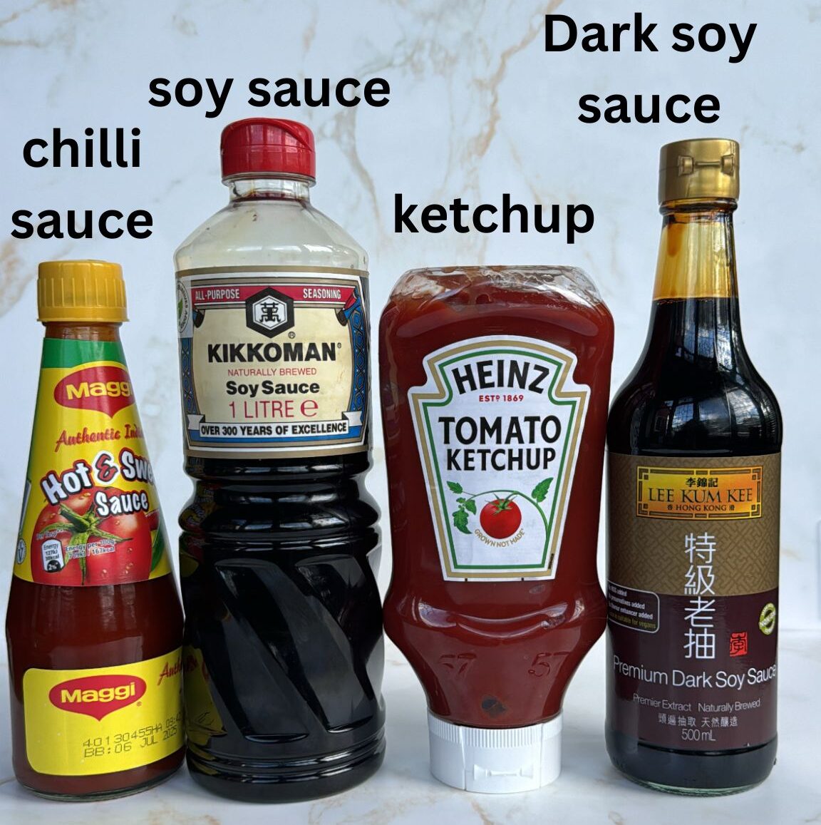 Bottles of sauces used for chilli paneer (ketchup, dark soy sauce, soy sauce, chilli sauce)