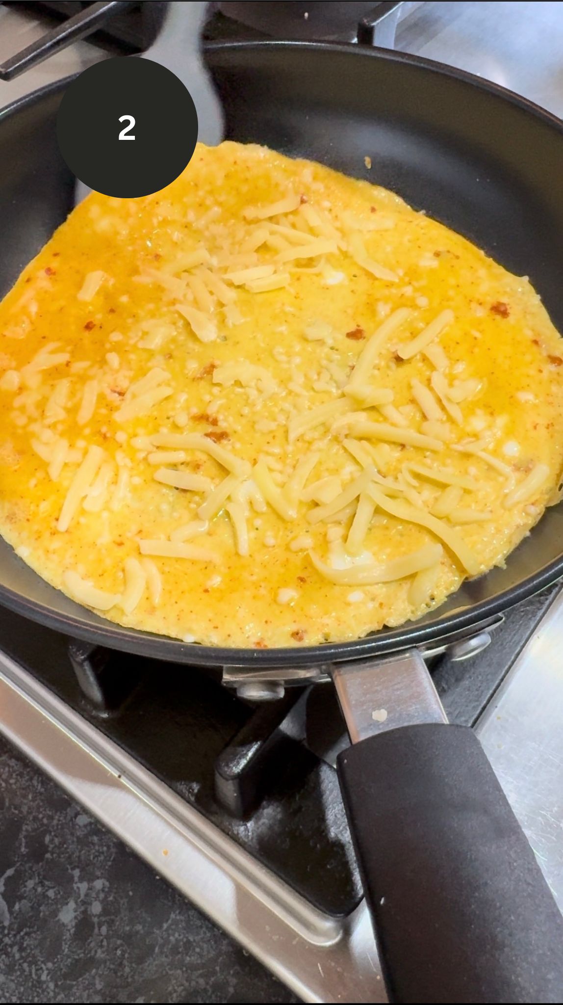 omelette on pan with sprinked cheese