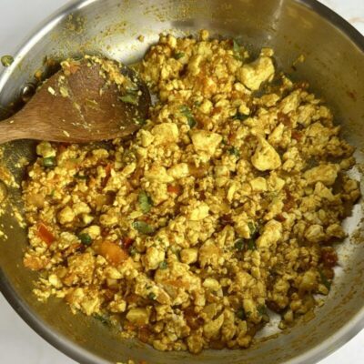 Spiced tofu scramble in a pan with a spoon