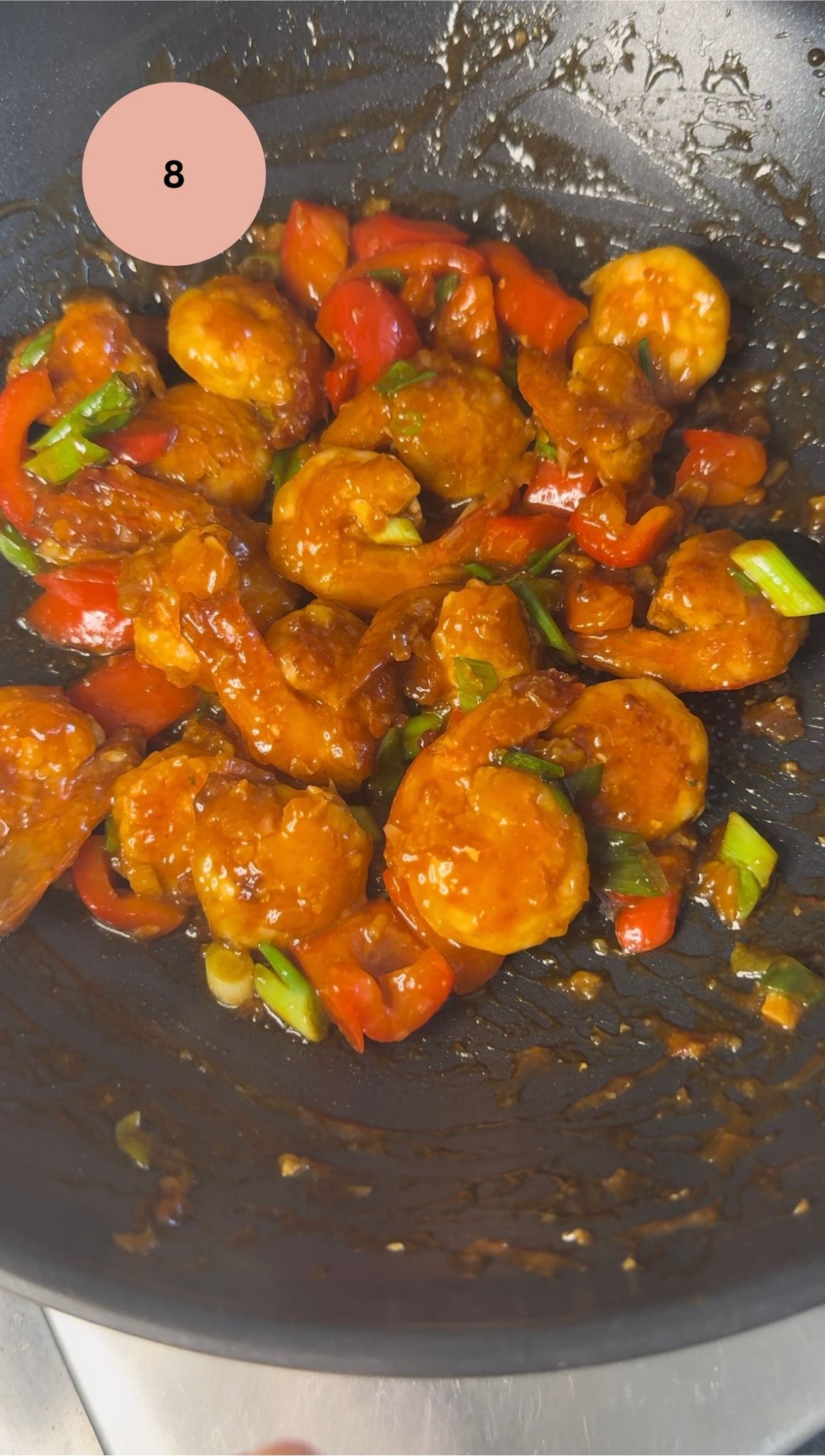 prawns coated in sauce with spring onions added