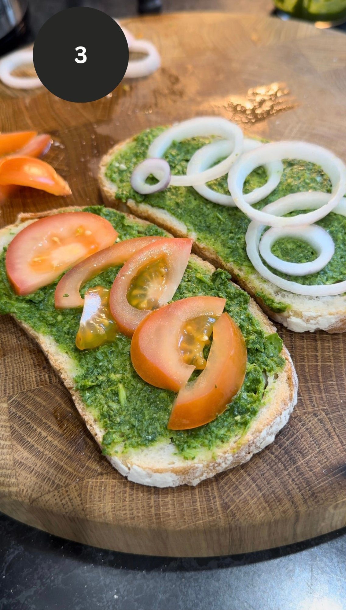 two slices of bread with green chutney, and sliced tomatoes and onions