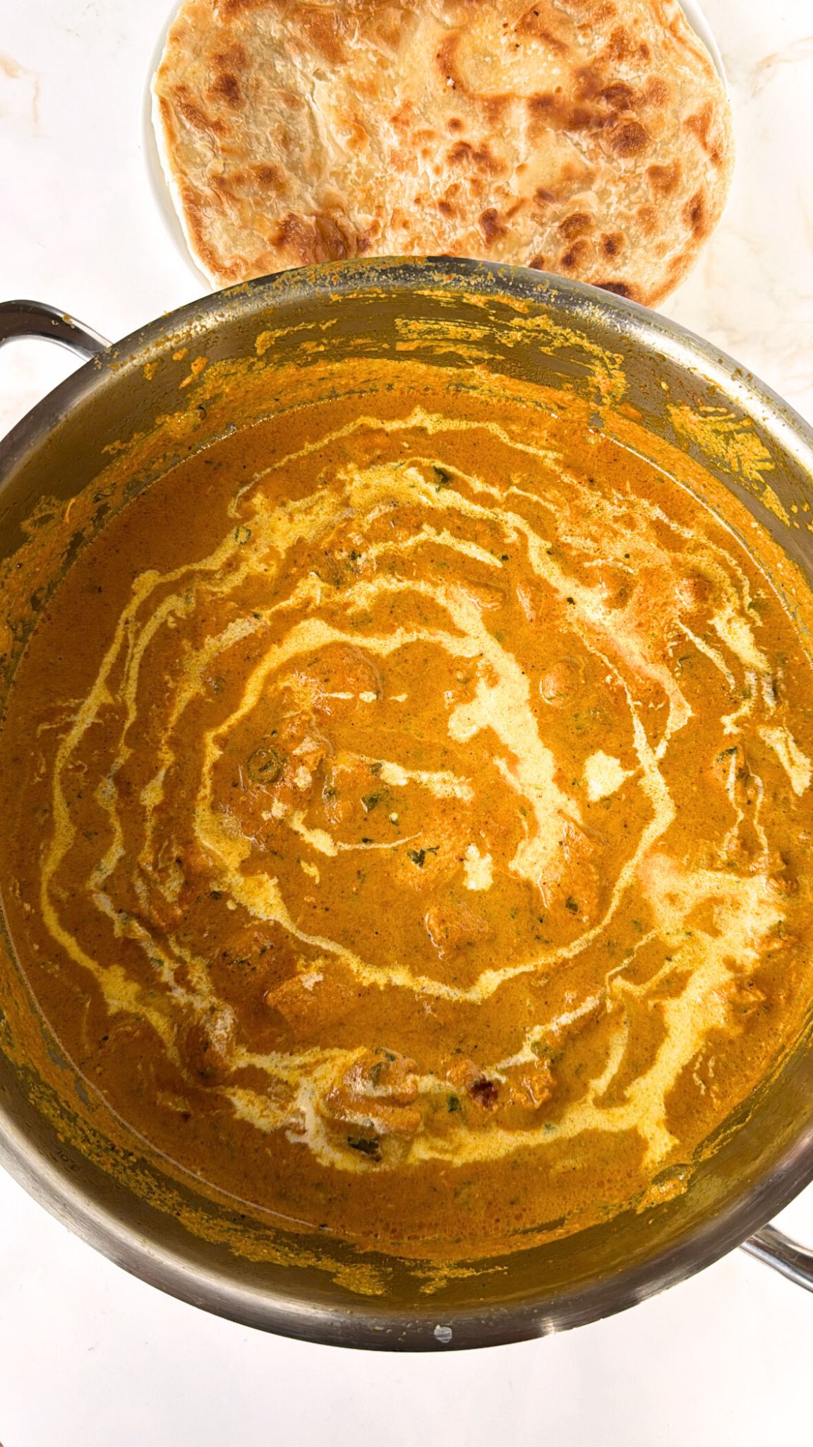 Butter chicken with paratha on side