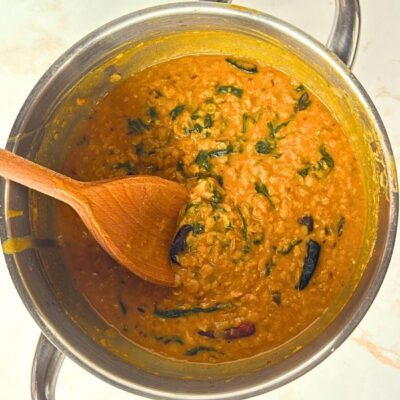 dahl in a steel saucepan and wooden spoon in it