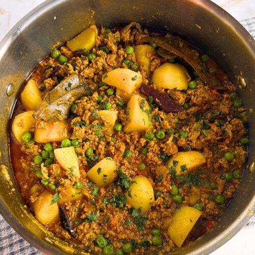 potatoes, spiced meat and peas in a pan