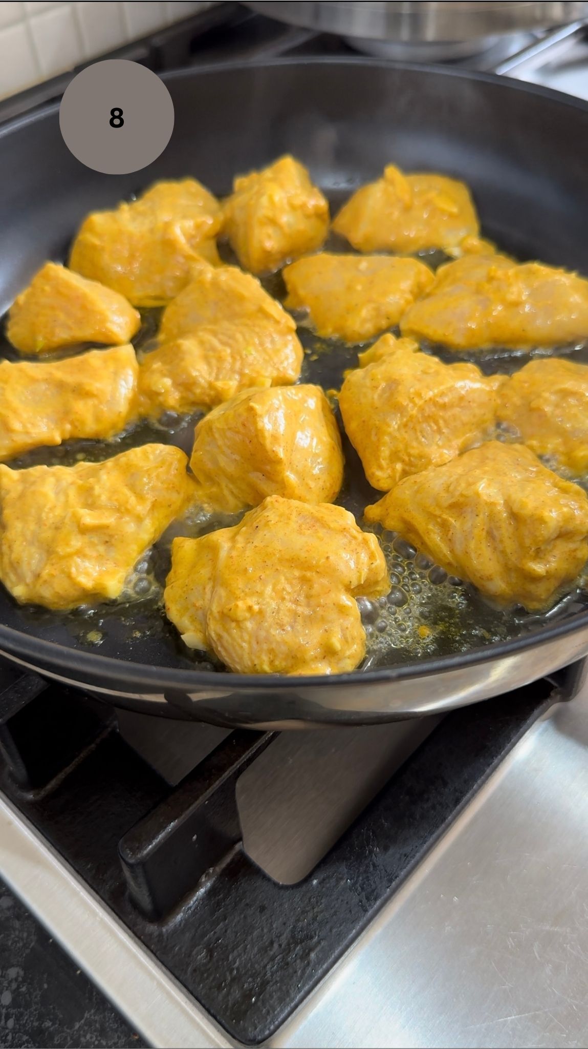 marinated chicken frying in fry pan