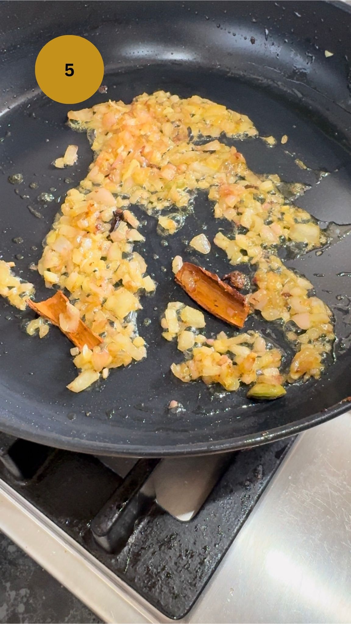 onions frying with aromatics in fry pan