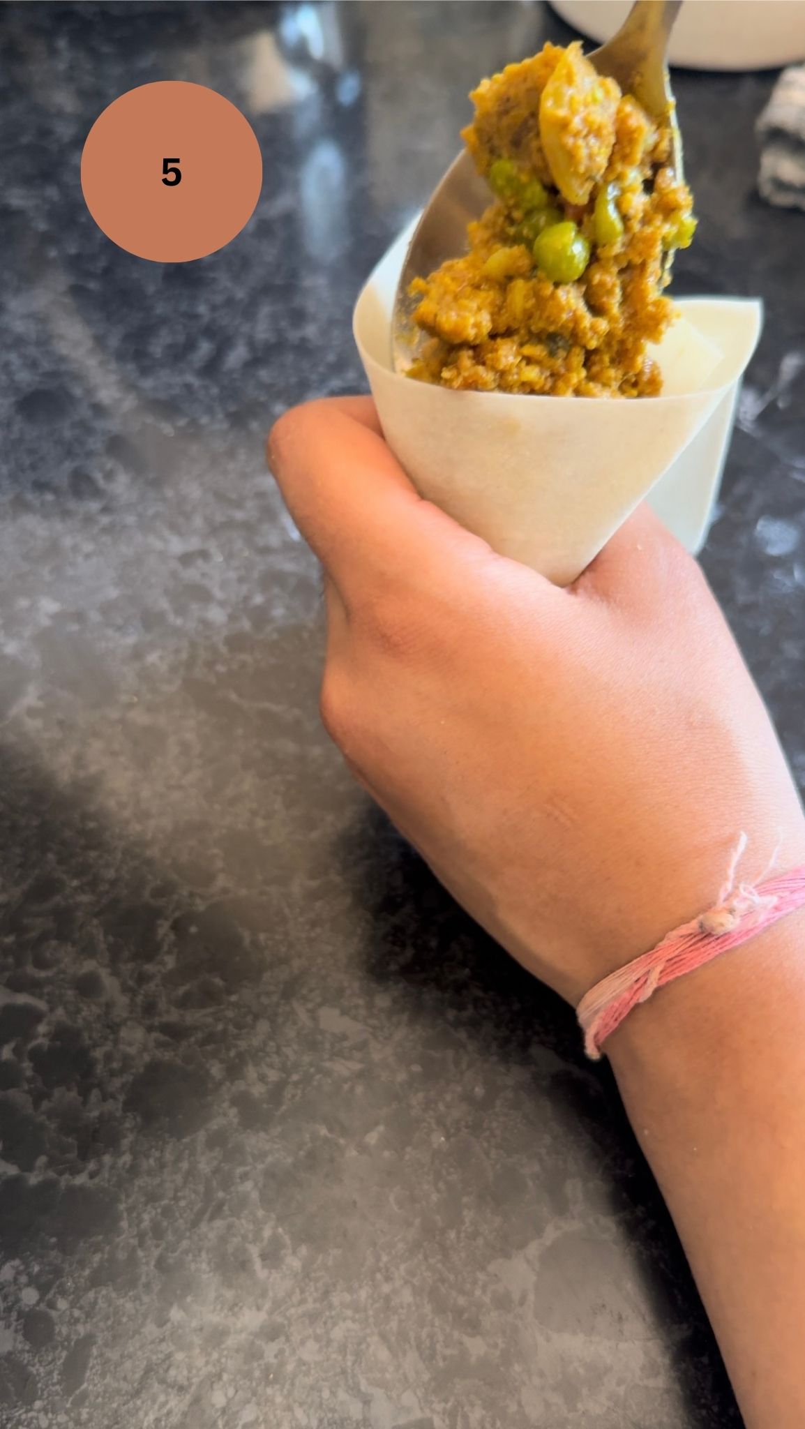 adding the filling to the samosa pocket created