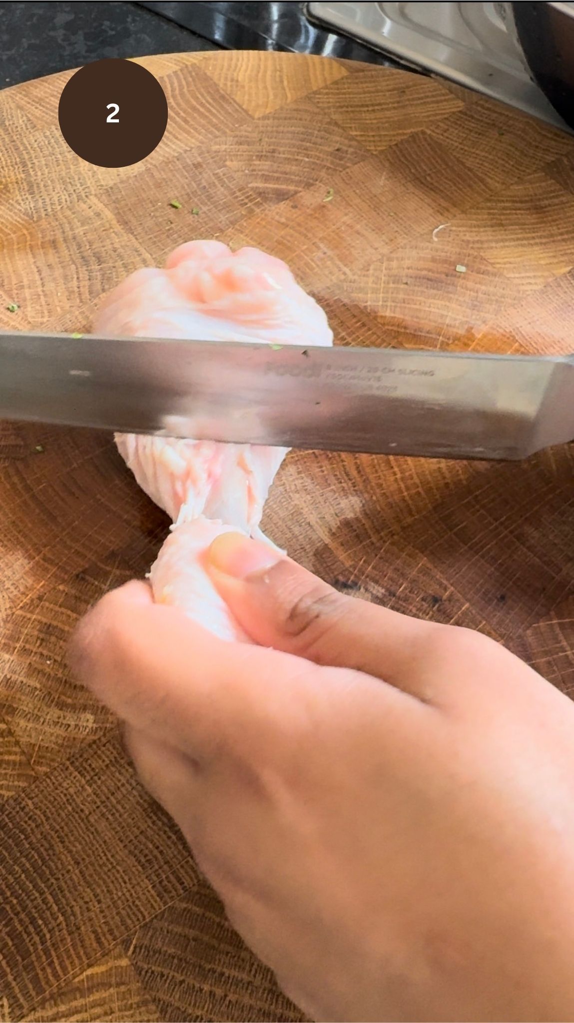 knife pushing meat upwards to expose chicken bone