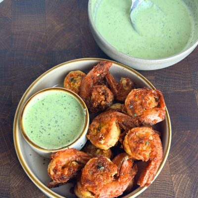 Prawn koliwala on a plate with chutney on the side