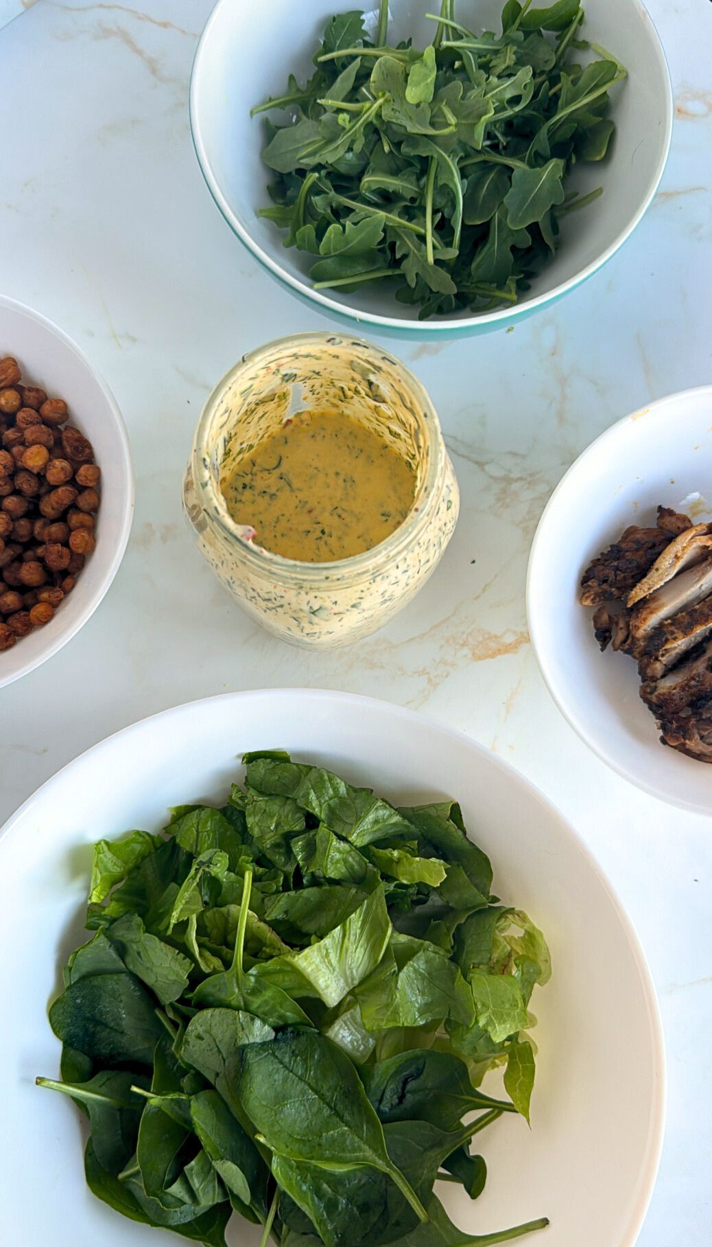 salad dressing with bowls of ingredients surrounding it