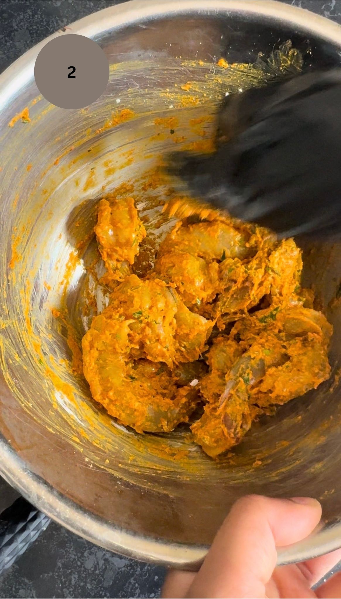 prawns being mixed in steel bowl